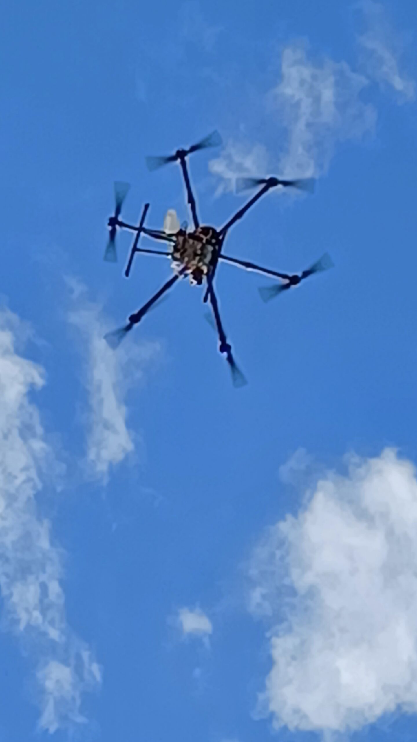 Hexacopter drone in flight against blue sky with IceConeFeed S-Band antenna visible simulating LEO satellite pass