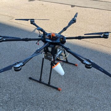 Hexacopter drone on ground side view, IceConeFeed S-Band 2490 MHz antenna mounted underneath for ESA indoor navigation test campaign